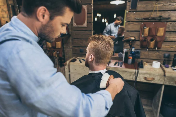 Красивий чоловік з перукарем в перукарні — стокове фото