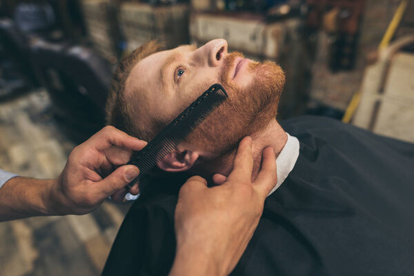 barber combing customers beard
