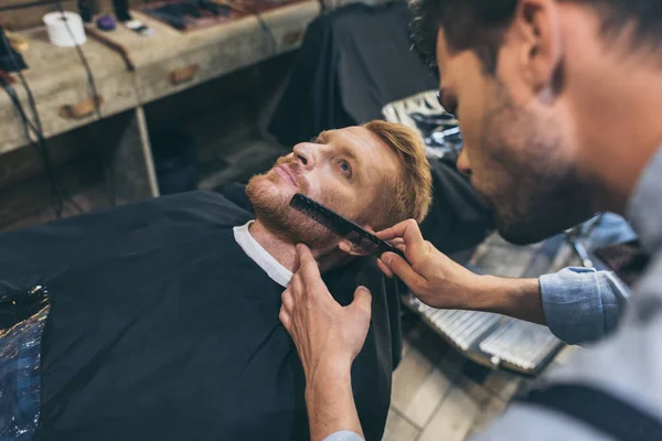 Barbero peinando barba clientes —  Fotos de Stock