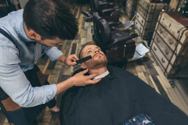 Barbero peinando barba clientes — Foto de Stock