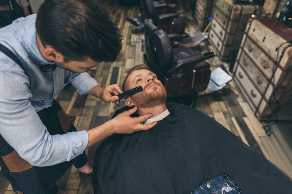 barber combing customers beard