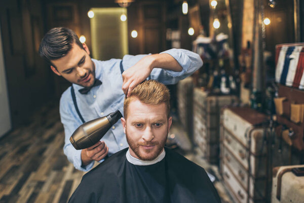 barber drying hair of customer