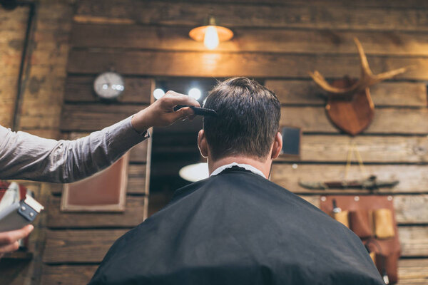 barber combing hair of customer