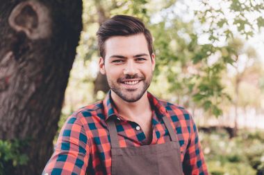 genç gülümseyen bahçıvan önlük