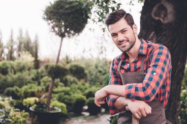 young smiling gardener in apron clipart