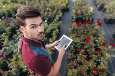 Bahçıvan Bahçe çalışması sırasında tablet ile