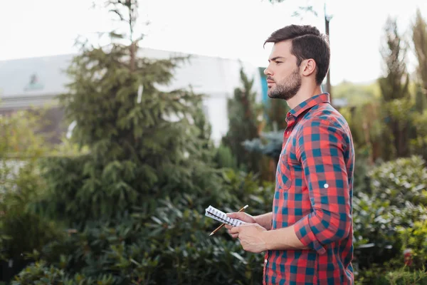 Jardinero con cuaderno en las manos — Foto de Stock