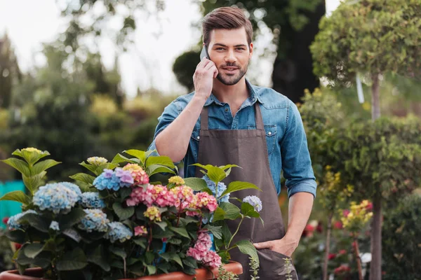 Садовник со смартфоном в саду — стоковое фото