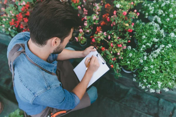 Jardinero haciendo notas durante el trabajo — Foto de Stock