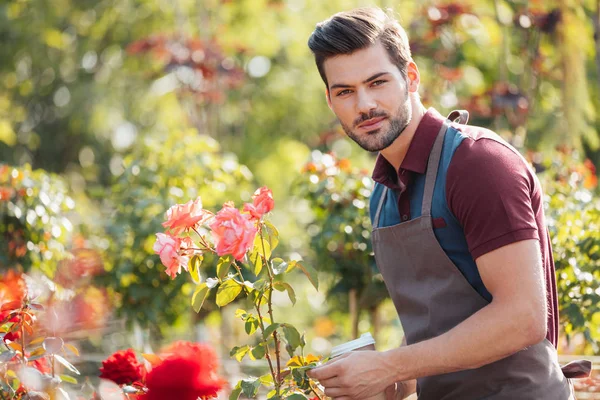 Gardener with coffee to go in garden — Stock Photo, Image