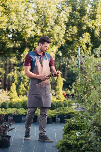 Jardinier avec tablette pendant le travail dans le jardin — Photo