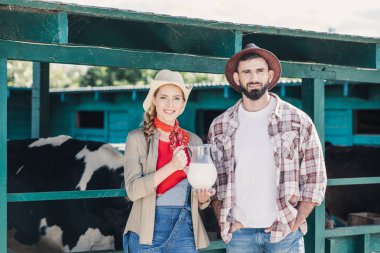 farmers with fresh milk at cowshed clipart