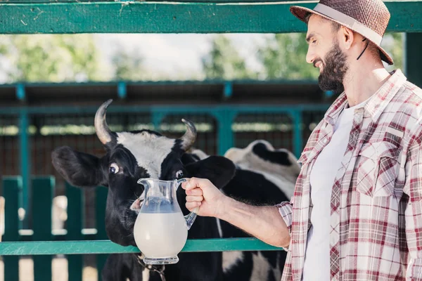 Bonde med färsk mjölk i stall — Stockfoto