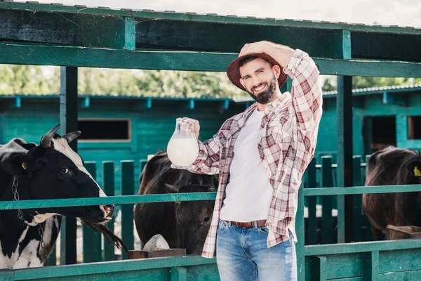Agricultor com leite fresco em estábulo — Fotografia de Stock