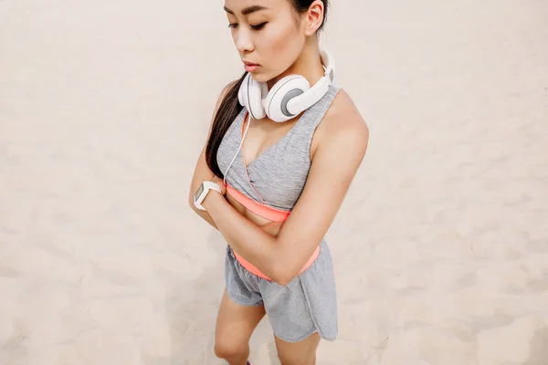 Asiática esportista com fones de ouvido — Fotografia de Stock