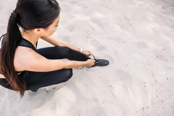 Sportswoman tying shoelaces — Free Stock Photo