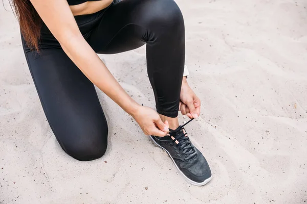 Sportswoman tying shoelaces — Free Stock Photo