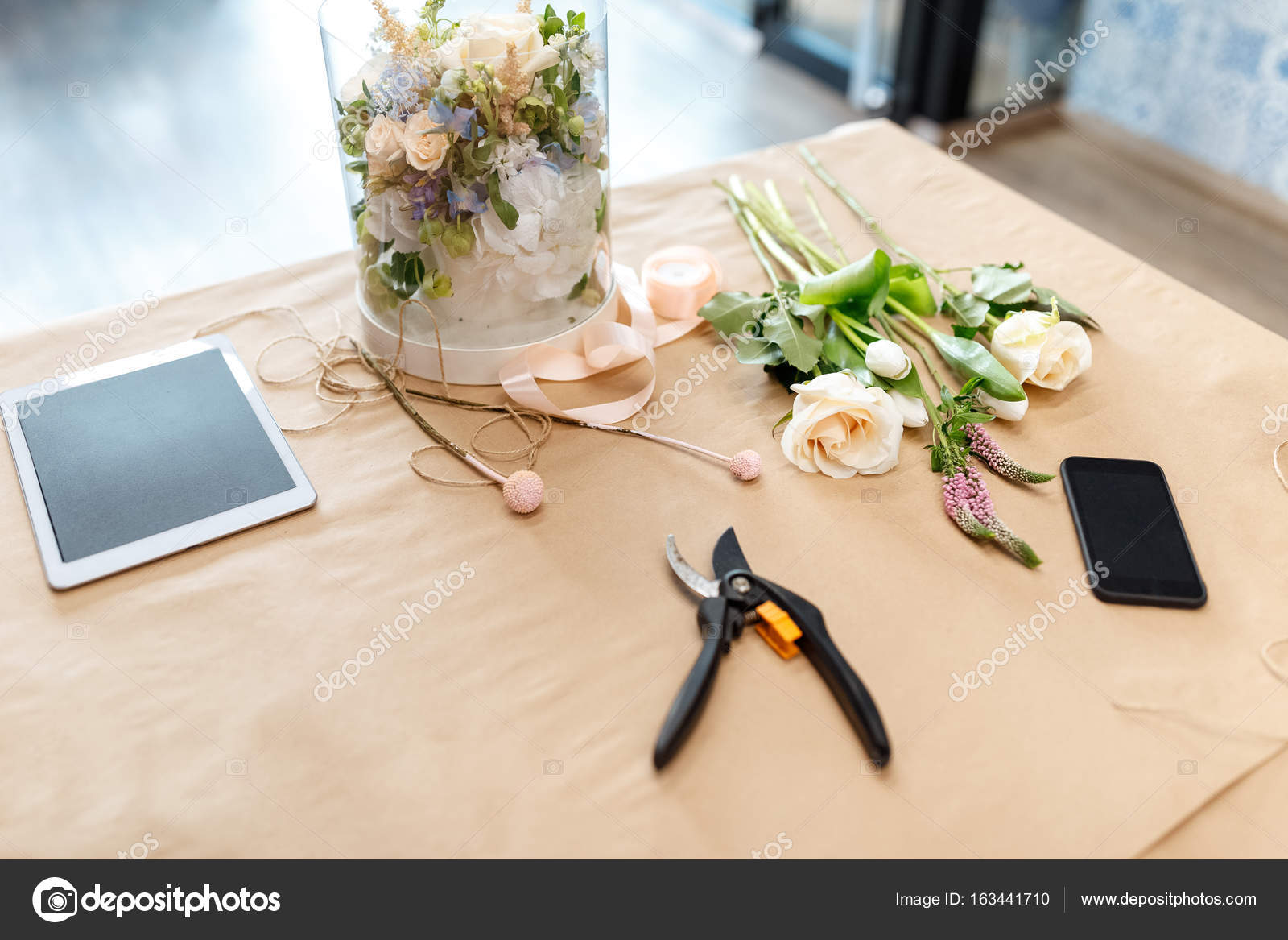 Flowers and digital tablet on craft paper Stock Photo by