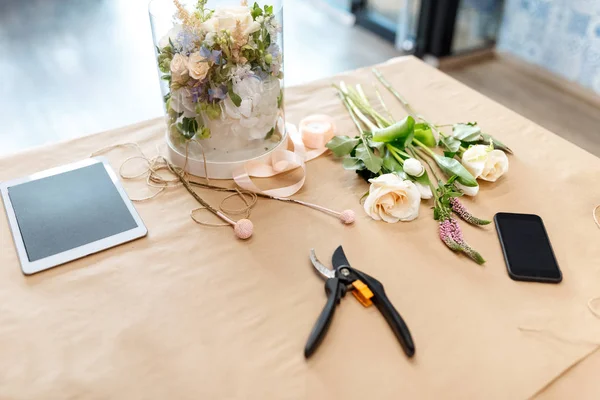 Blumen und digitales Tablet auf Bastelpapier — Stockfoto