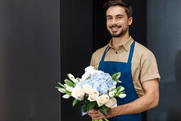 Schöner Blumenhändler mit Blumen — Stockfoto