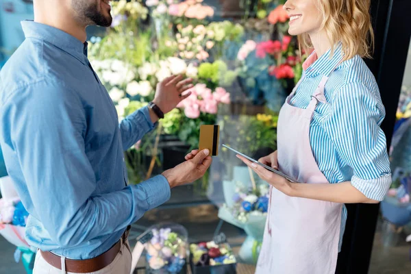 Florist and buyer with credit card — Stock Photo, Image