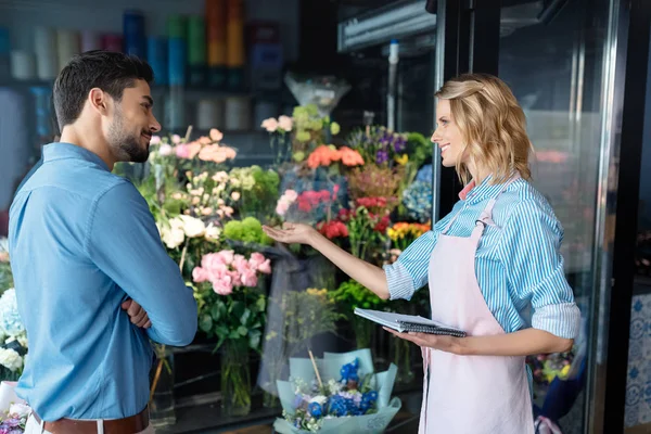 Флорист і покупець в квітковому магазині — стокове фото