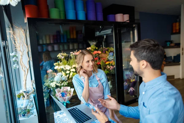 Florista y cliente con portátil — Foto de Stock