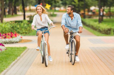 happy couple riding bicycles clipart
