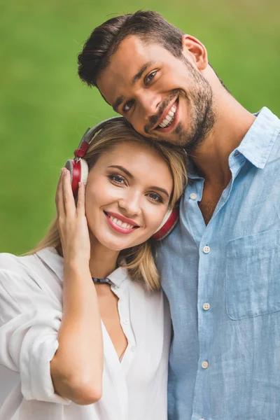 Χαμογελαστό γυναίκα στα ακουστικά και ο φίλος — Φωτογραφία Αρχείου