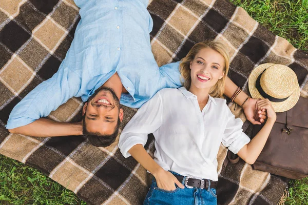 Couple lying on blanket on ground — Stock Photo, Image