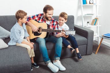 father with sons playing guitar clipart