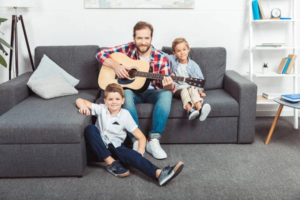 Father with sons playing guitar