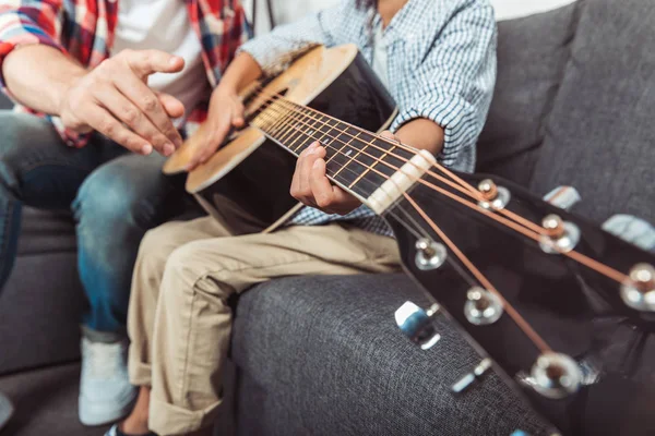 Baba oğul gitar çalıyor.