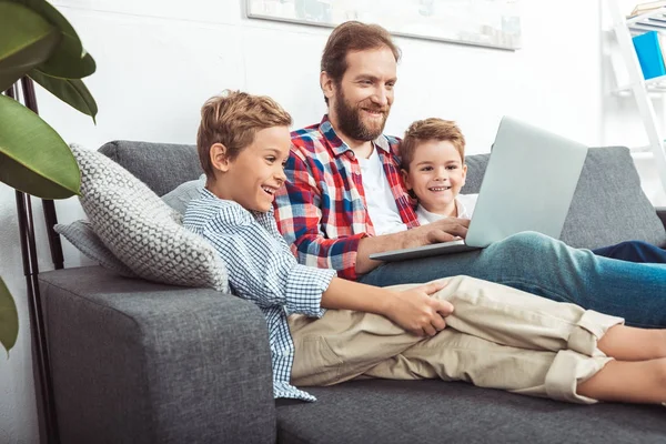 Pai com filhos usando laptop — Fotografia de Stock