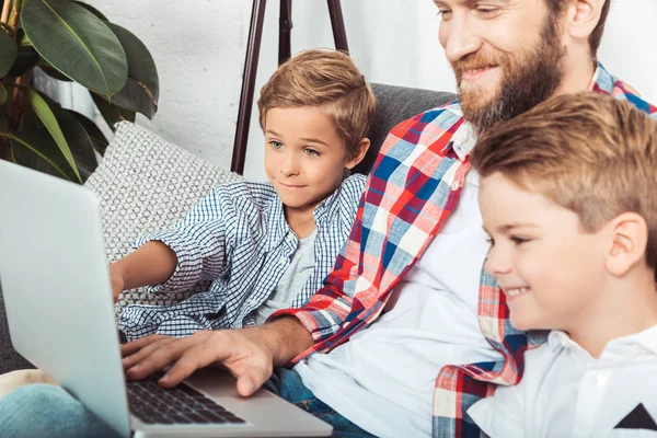 Ojciec z synami za pomocą laptopa — Zdjęcie stockowe