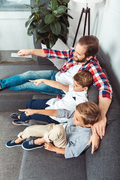 Pai com filhos assistindo tv — Fotografia de Stock