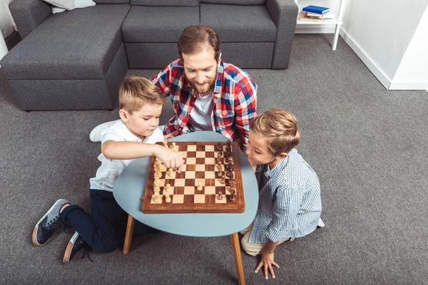 Father with sons playing chess — Stock Photo, Image