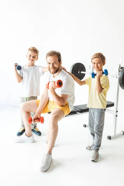 Father and sons exercising with dumbbells — Stock Photo, Image