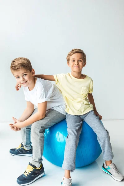 Мальчики сидят на фитнес-мяче — стоковое фото
