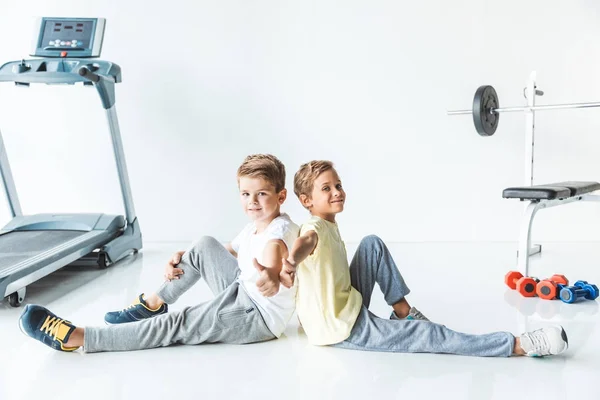 Boys showing thumbs up in gym — Stock Photo, Image