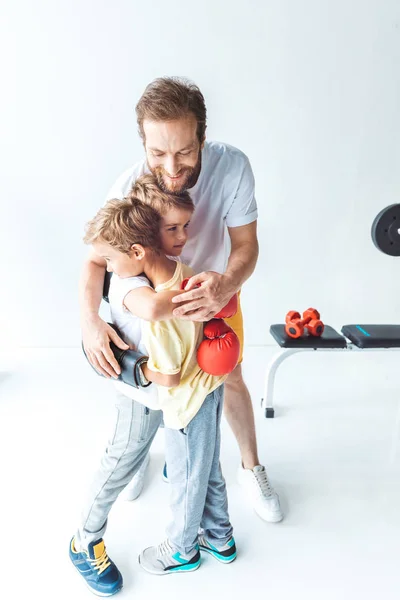 Отец обнимает сыновей в боксёрских перчатках — стоковое фото