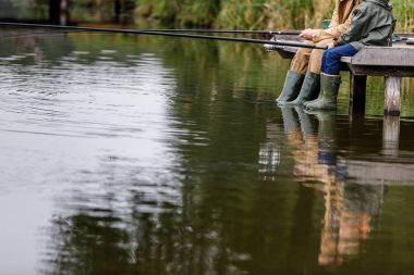 father and son fishing on lake clipart