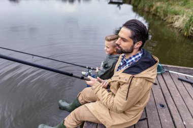 father and son fishing together  clipart