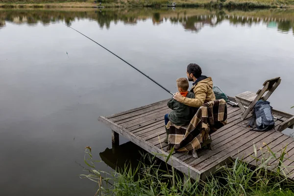 Отец и сын рыбачат на пирсе — стоковое фото