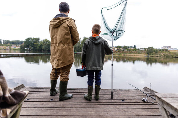 father and son fishing with rod and net 