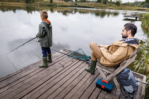 father and son fishing with rods