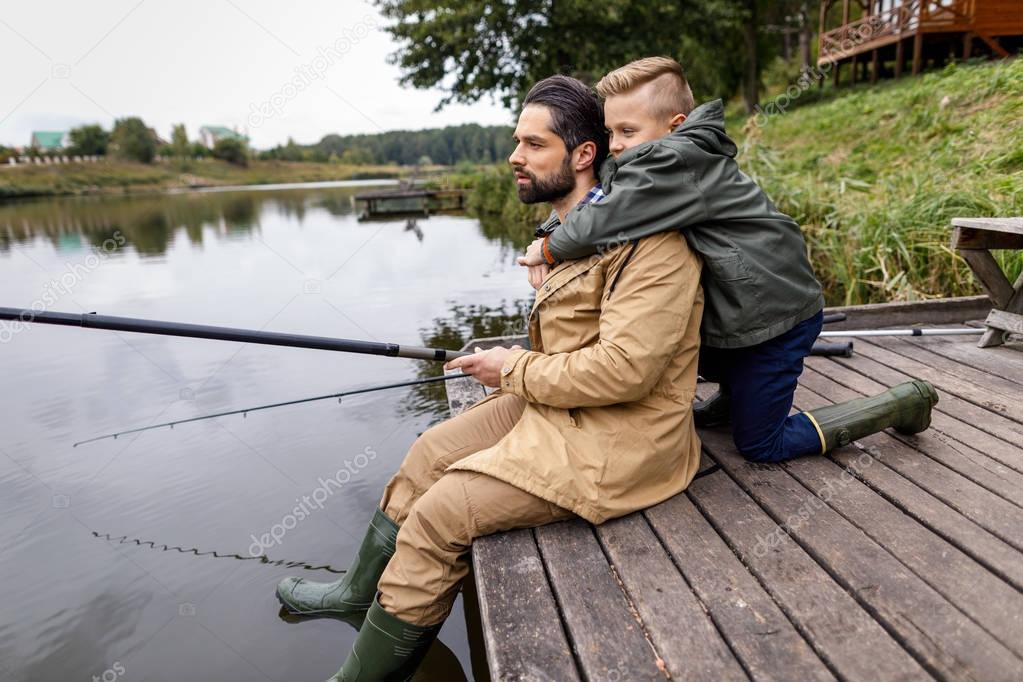 father and son fishing with rods 