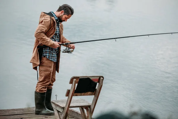 Man fishing with rod on pier — Free Stock Photo