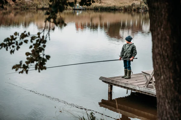 Маленький хлопчик риболовля зі стрижнем — стокове фото