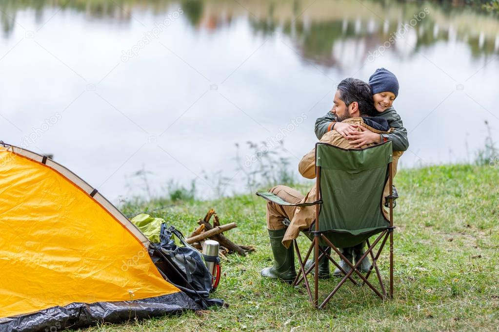 father and son hugging in camping